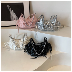 Close-up of quilted crescent bags in multiple colors featuring silver chain and bow detail