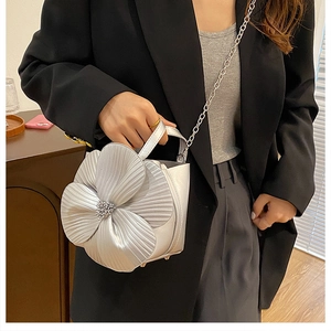 Close-up of silver floral bucket bag with 3D pleated petals and elegant pearl center