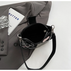 Detail showing the inner storage of the black Y2K shoulder bag with pink heart patch