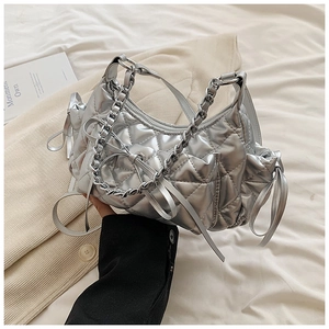 Detailed view of silver quilted hobo bag with metallic finish and bow chain decorations