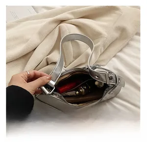 Vue détaillée de l'intérieur du sac baguette argenté montrant l'espace pour le maquillage