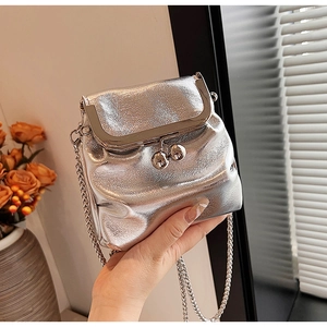 Détail du fermoir à clapet argenté et de la bandoulière en chaîne du sac à main