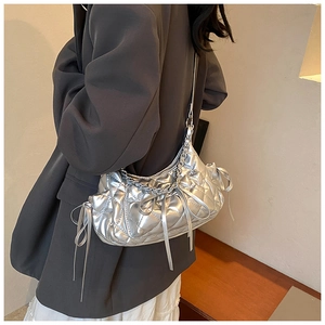 Close-up of a silver quilted hobo bag featuring a metallic finish and chic bow detailing