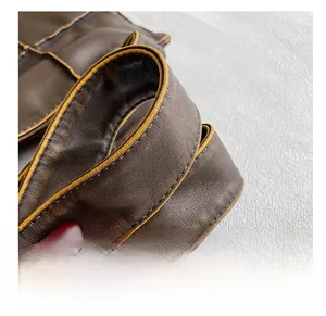 Detail of dark brown leather tote with contrasting yellow stitching and lychee texture