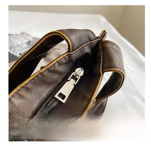 Close-up of high-quality silver metal zipper on vintage brown leather tote bag