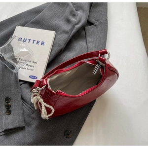 Interior view of red leather underarm bag with smooth lining and pearl charm detail
