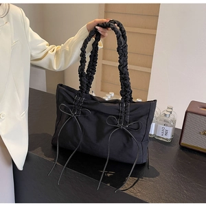 Detail van nylon tas met geplooide handvatten, strikken en contraststiksels voor dames