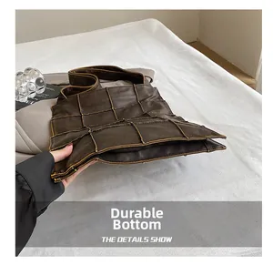 Detail view of the durable wear-resistant bottom on this brown leather shoulder tote bag