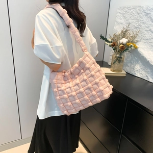 Detailed view of pink woven puffer shoulder bag with soft textured bubble material