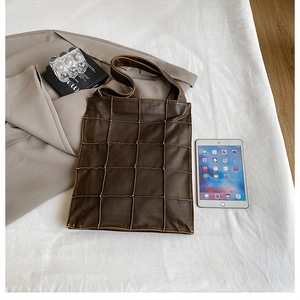 Quilted dark brown leather tote bag with tablet inside showing large storage capacity