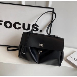 Detail shot of the matte black faux leather tote with a silver twist lock closure