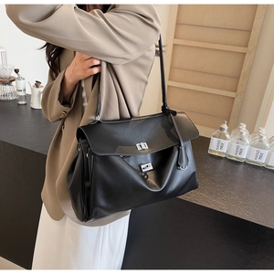 Side view of black large capacity shoulder bag with silver twist lock on model