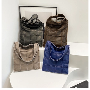 Macro shot of patchwork quilted tote bags in charcoal, brown, taupe and cobalt blue