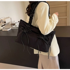 Chique zwarte shopper met geplooide handvatten en witte strikken voor een urban stijl