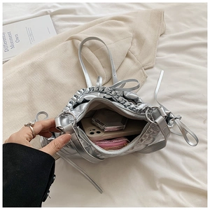 Detailed interior view of silver quilted hobo bag showing spacious capacity for phone and makeup
