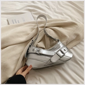 Gros plan du sac à bandoulière argenté style punk avec ceintures à œillets métalliques