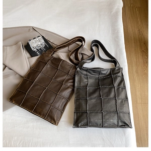Detail of premium leather tote bags with distinctive quilted stitching in black and brown