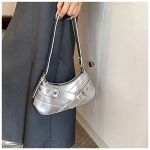 Détail du sac hobo argenté Y2K avec lanières à boucles et accents d'oeillets en métal