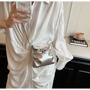Detail of silver pleated cloud bag with metallic sphere clasp and sleek chain strap