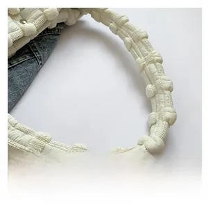 Detail showing the soft padded shoulder strap of the white quilted puffy cloud bag