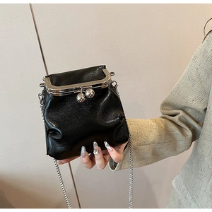 Détail du sac bandoulière noir avec fermoir à baiser argenté et bandoulière chaîne
