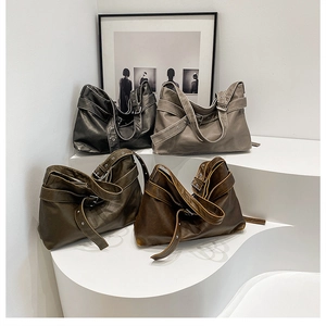 Close-up of four colors of retro leather shoulder bags with metal eyelet strap detail