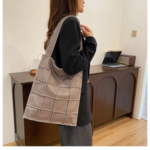 Detail of taupe tote bag with quilted square stitching and soft leather texture