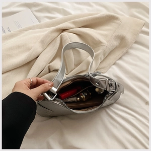 Détail du sac baguette argenté métallisé montrant la capacité de rangement avec rouge à lèvres