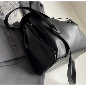 Detailed view of black matte leather shoulder bag with sleek silver buckle on the strap