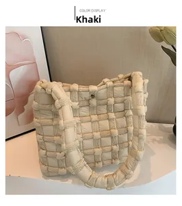 Detail view of khaki woven quilted puffer tote bag with magnetic snap and checkered texture