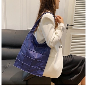 Blue patchwork leather tote bag styled with a white blazer for a chic commuting look
