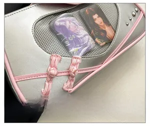 Macro detail of silver bag with pink frog button decor and clear mesh window