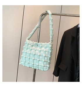 Detail of mint green puffy shoulder bag with square quilted texture and soft fabric finish
