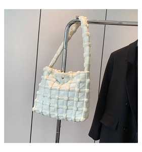 Detailed close-up of quilted cream bubble tote bag with padded grid texture on a hanger