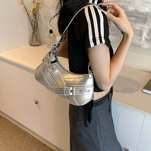 Sac sous le bras argenté métallique style Y2K avec boucles porté par un mannequin