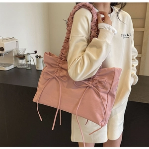 Detailopname van een roze nylon draagtas met geplooide riemen en schattige strikjes