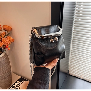 Détail d'un mini sac en cuir noir avec chaîne et cadre métallique argenté rétro
