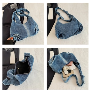 Detailweergave van grote denim schoudertas met gewassen textuur en ruim interieur