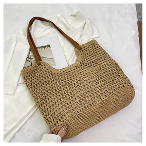 Detailed close-up of woven cotton mesh tote bag with durable brown leather shoulder straps