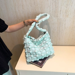 Close-up of mint green woven puffer shoulder bag with soft cloud-like texture