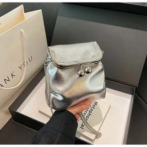 Détail du sac argenté métallisé à fermoir kiss-lock avec chaîne et fini miroir