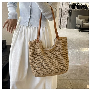 Detail of woven mesh texture and brown leather handles with rivets on summer tote bag