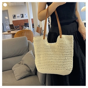 Detail of hand-woven hollow knit beach tote with brown leather shoulder straps
