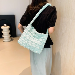 Detailed view of the mint green puffed woven shoulder bag featuring textured quilt pattern
