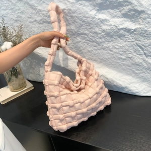 Close-up of pink quilted puffer bag with soft woven texture and comfortable top handle
