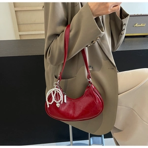 Deep red crescent underarm bag with glossy leather, pearl heart charm and zipper detail