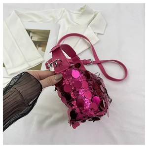 Detail of pink sequin handbag with leather handle and silver metal hardware accents