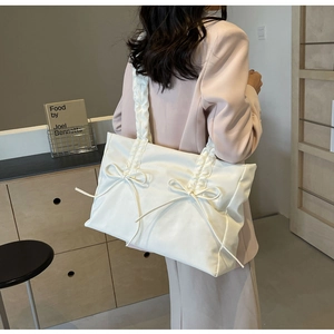 Zijaanzicht van witte shopper met strikken en een schouderband met ruches
