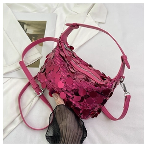 Detail of hot pink handbag featuring large circular sequins and silver metal zipper
