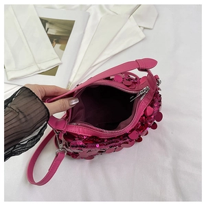 Top view of pink sequin handbag showing metal zipper closure and dark inner lining texture